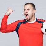 excited soccer player red t shirt holding football victory concept isolated white 2