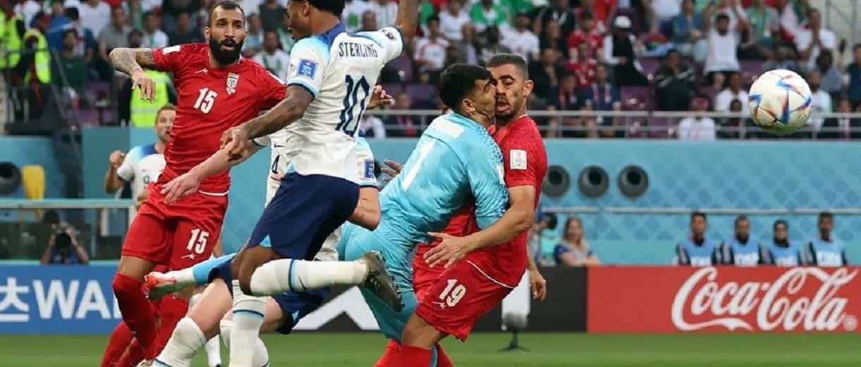 Com uniforme azul, goleiro Beiranvand., do Irã, tem choque feio com seu próprio companheiro durante jogo contra a Inglaterra 